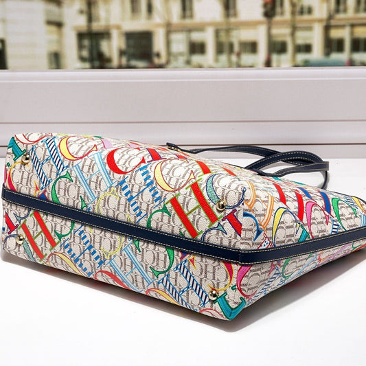 Colorful patterned handbag on a white surface with a blurred cityscape background